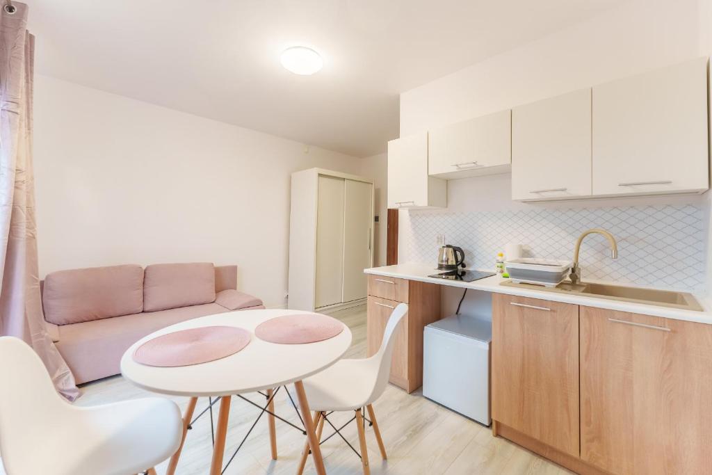 Nadmorski Apartament V by Holiday&Sun في جيبوفو: مطبخ صغير مع طاولة وكراسي في الغرفة
