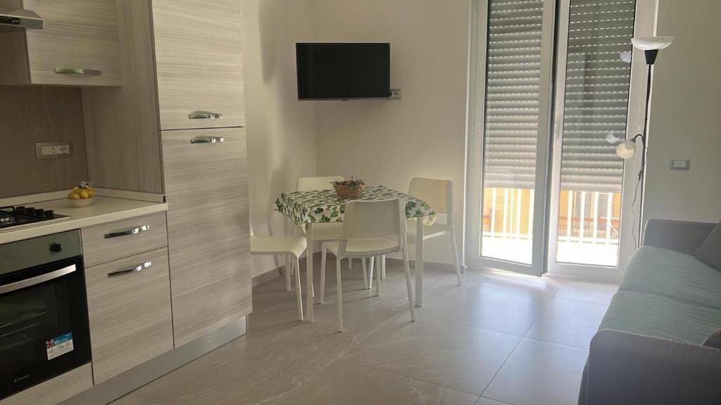 a kitchen with a table with chairs and a television at Alysia House in Naples