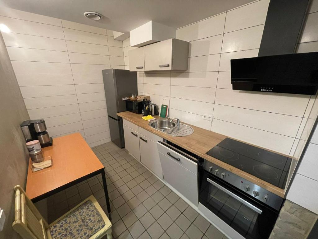 een kleine keuken met een wastafel en een fornuis bij KobyApartment Souterrain in Herford