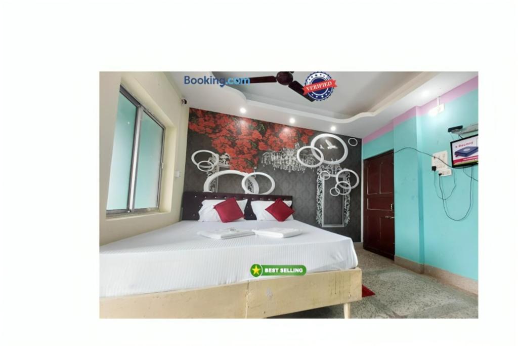 ein Schlafzimmer mit einem Bett und einer Wand mit Zeichnungen darauf in der Unterkunft Hotel J K Inn Puri Near Sea Beach in Puri