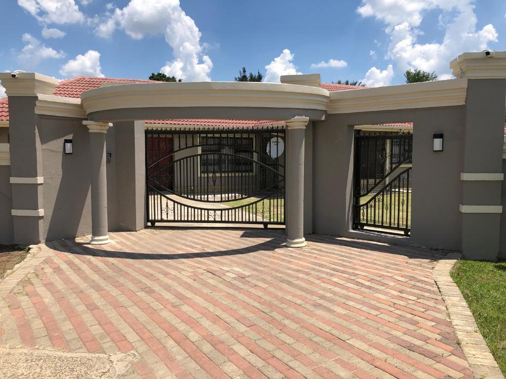 a house with a gate and a brick driveway at Icebolethu Guest House in Standerton