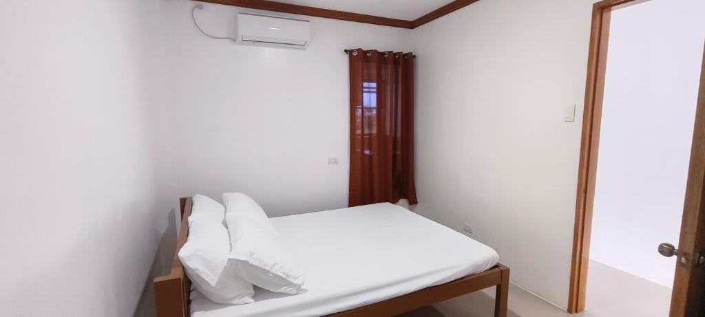 een kleine kamer met een bed en een spiegel bij Casa Victoria Pension House- Star Challenger in Somosomo