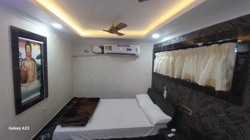 Habitación pequeña con cama y ventilador de techo. en Galaxy Inn, en Khurda