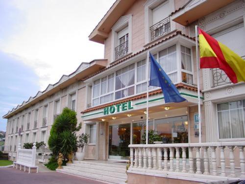 a hotel with two flags in front of it at Hotel Begoña Park in Gijón