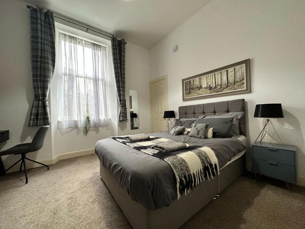 1 dormitorio con 1 cama, 1 silla y 1 ventana en City Lights Apartment en Edimburgo