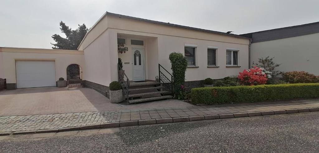 une maison blanche avec un escalier en face de celle-ci dans l'établissement Ferienwohnung Graße, à Görlitz