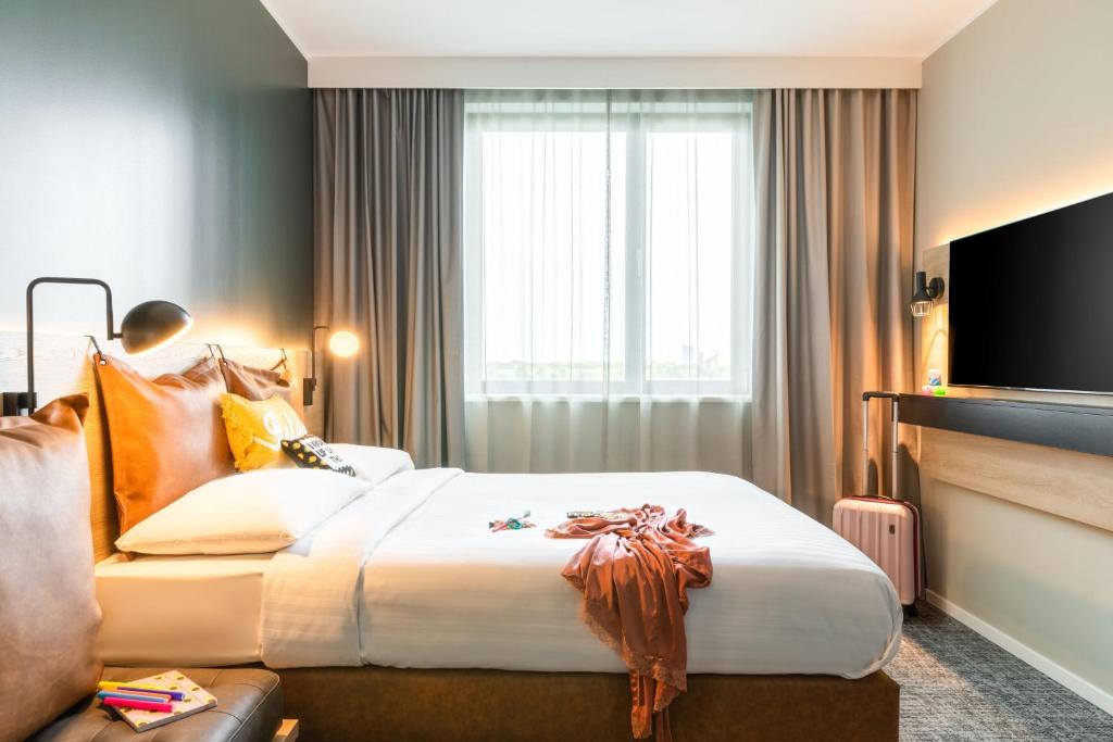 a hotel room with a bed and a television at Moxy Berlin Airport in Schönefeld