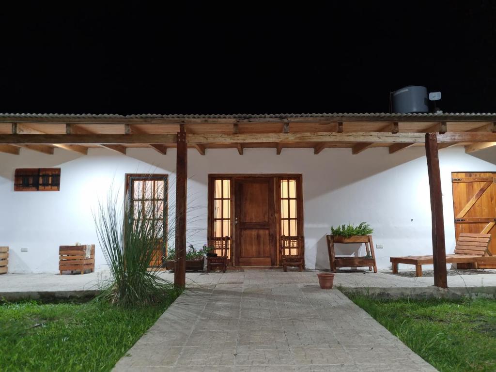 eine Veranda in einem weißen Gebäude mit einer Holztür in der Unterkunft La Blanca in Mercedes