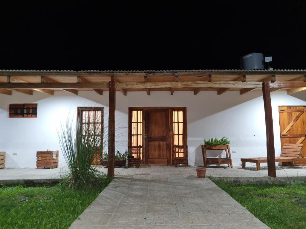 un porche de un edificio blanco con puerta de madera en La Blanca en Mercedes