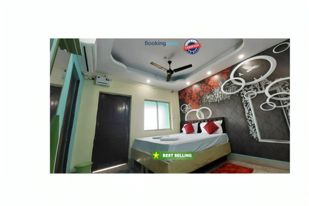 a bedroom with a bed and a wall with drawings on it at Goroomgo J K Inn Puri Sea View Room in Puri