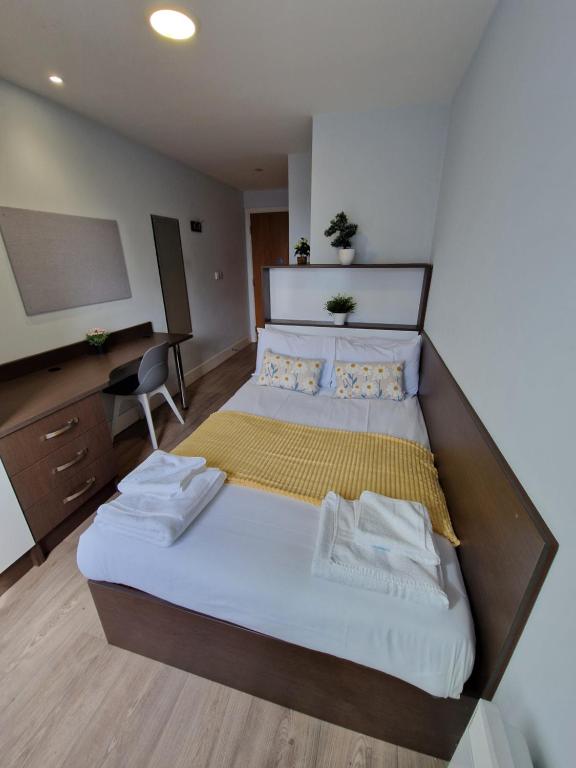 a bedroom with a large bed and a desk at Vitality Hotels in Birmingham