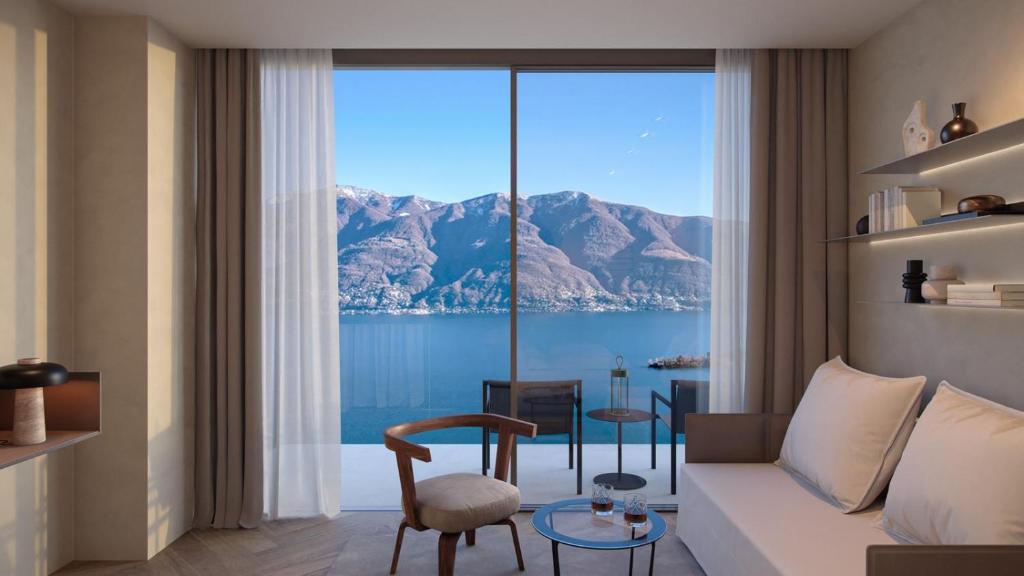 un soggiorno con divano e una grande finestra di Exclusive Boutique Hotel Elisabetta a Ronco sopra Ascona