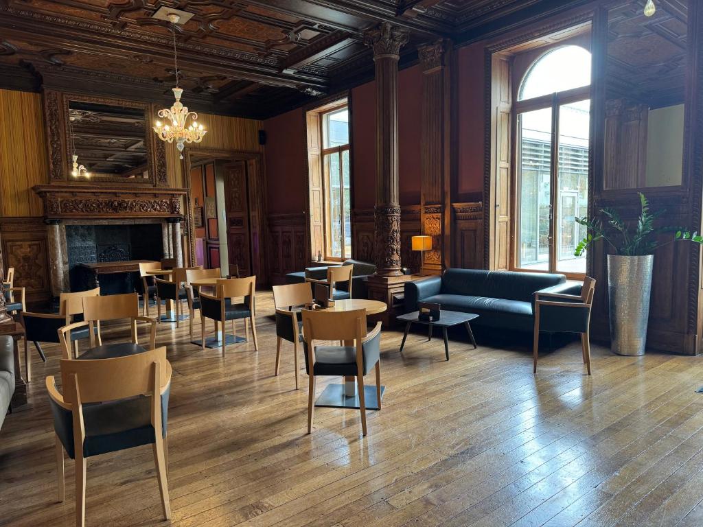 a living room with a couch and tables and chairs at Castel de Pont-a-Lesse in Dinant