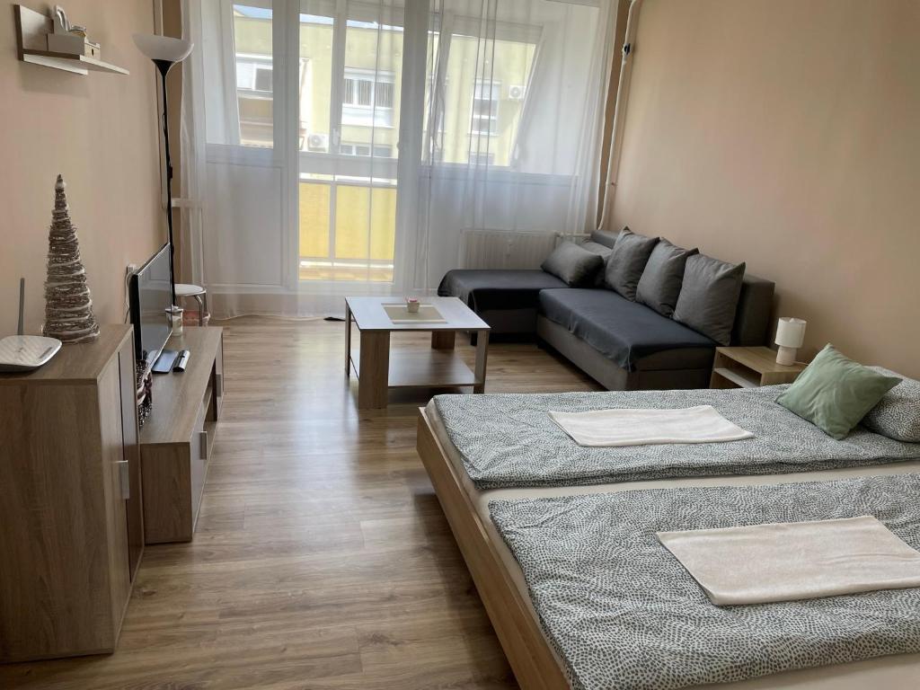 sala de estar con 2 camas y sofá en Kiss Vendégház 1. en Kaposvár