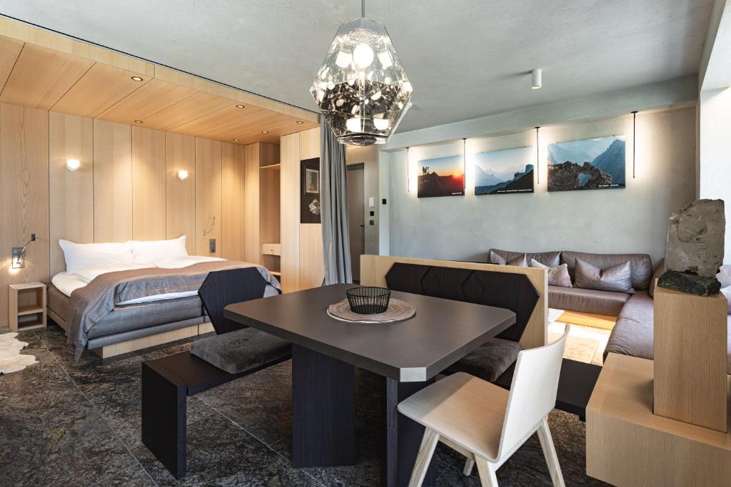 Habitación de hotel con cama y comedor en Wachtler Dolomite Apartments, en San Candido