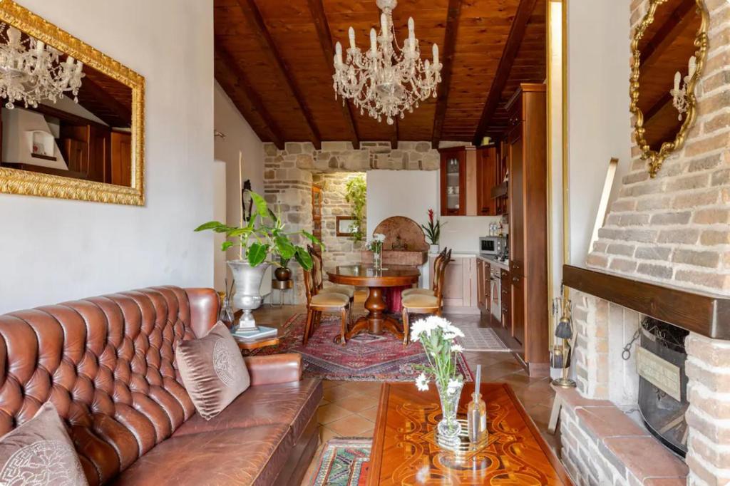ein Wohnzimmer mit einem Ledersofa und einem Tisch in der Unterkunft Affascinante appartamento nel Castello. in Moniga