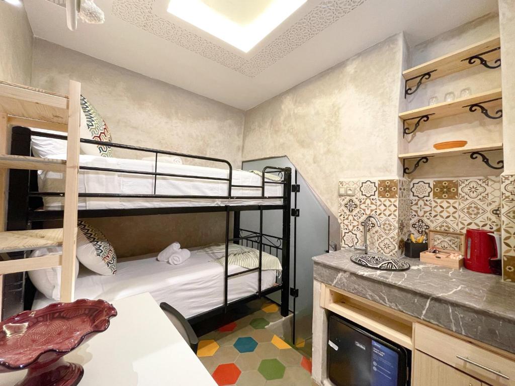 Pokój z 2 łóżkami piętrowymi i telewizorem w obiekcie Le Studio 46 w mieście Tanger