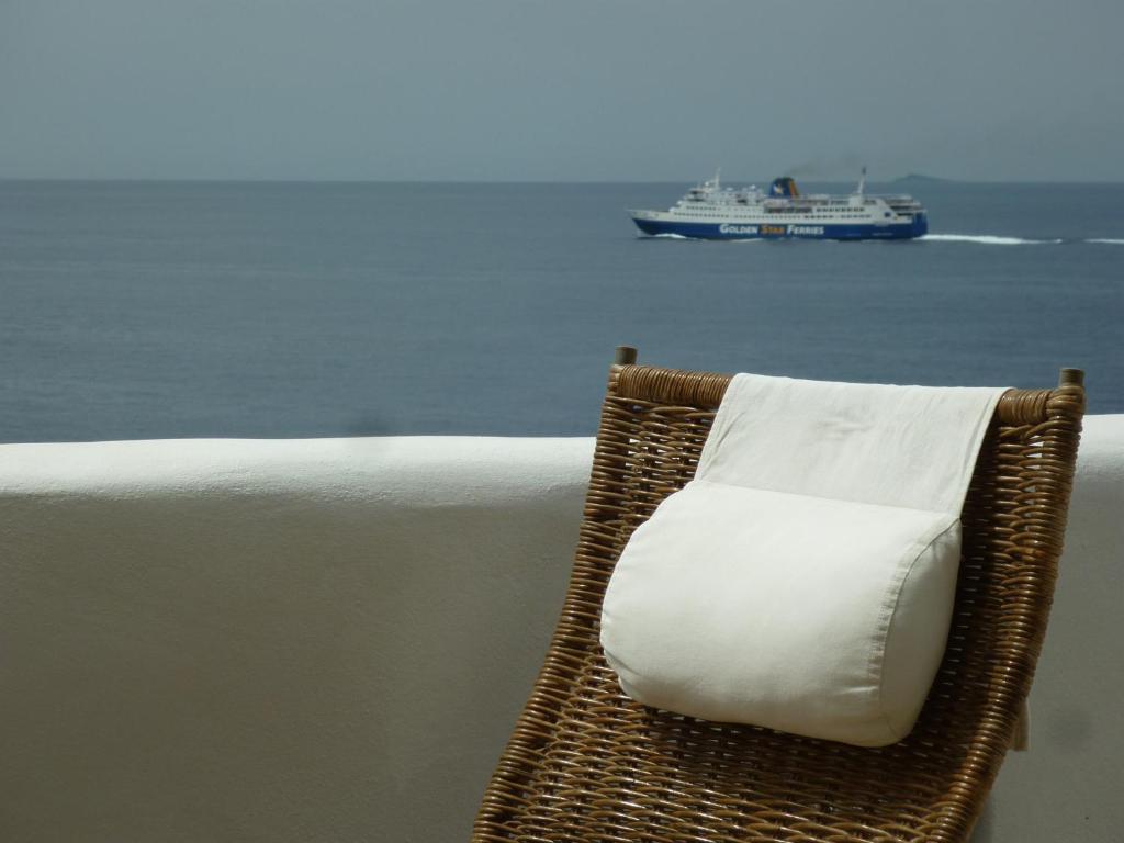 een rieten stoel met een wit kussen voor de oceaan bij Akti Giannaki in Kardhianí