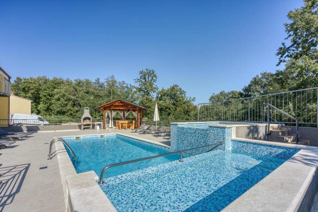 a swimming pool with a gazebo in the background at Pool House Klarina - Happy Rentals in Pićan