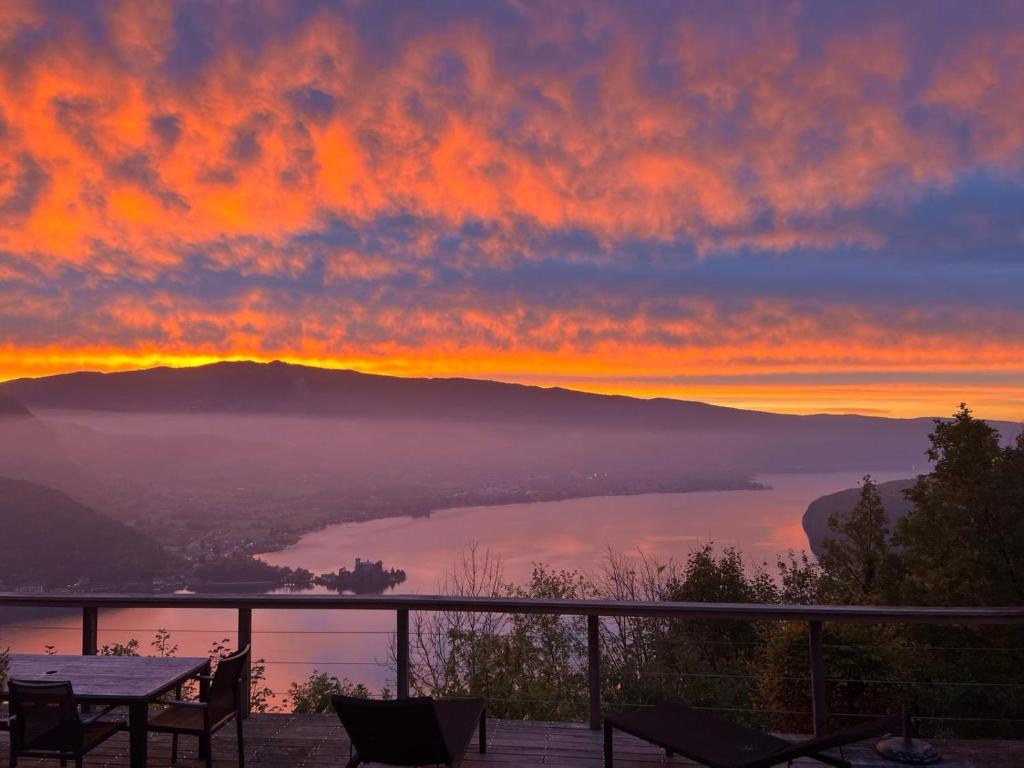 - un coucher de soleil sur un lac avec une table et des chaises dans l'établissement La Closette, à Rovagny