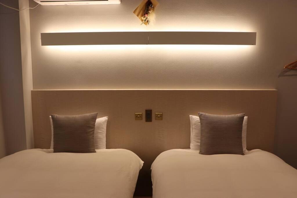 2 Betten nebeneinander in einem Zimmer in der Unterkunft ホテル SHUNJU Dosse 1日1組様限定 in Kyoto