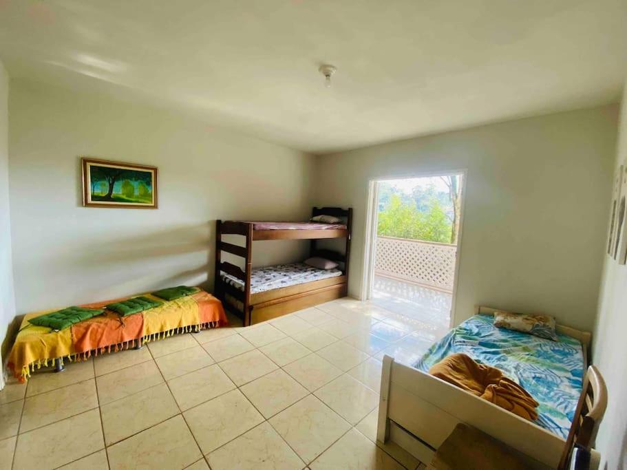 sypialnia z 2 łóżkami piętrowymi i oknem w obiekcie Chácara Aconchegante com Piscina e Salão de Festas w mieście Embu