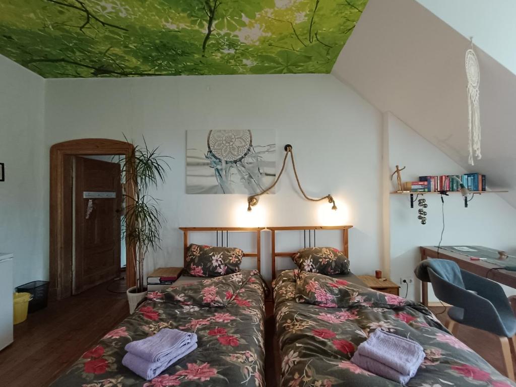 Schlafzimmer mit einem Bett, einem Schreibtisch und einer Decke in der Unterkunft RuheOase mit Baumkronenblick in Naundorf