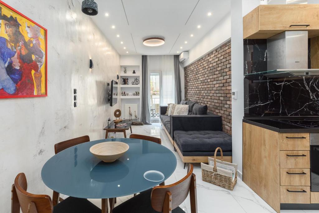 een keuken en een woonkamer met een blauwe tafel en stoelen bij Affogato by halu!: Bright and modern apartment in Thessaloniki