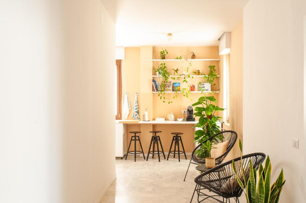 um quarto com cadeiras e um balcão com plantas em Four Rooms Alghero em Alghero