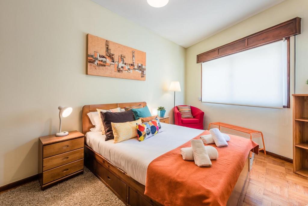 1 dormitorio con 1 cama grande y 1 silla roja en GuestReady - Sweet & Relax Flat, en Oporto