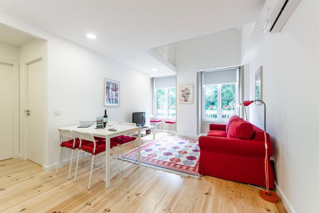 een woonkamer met een rode bank en een tafel bij GuestReady - Belas Artes Duplex in Porto