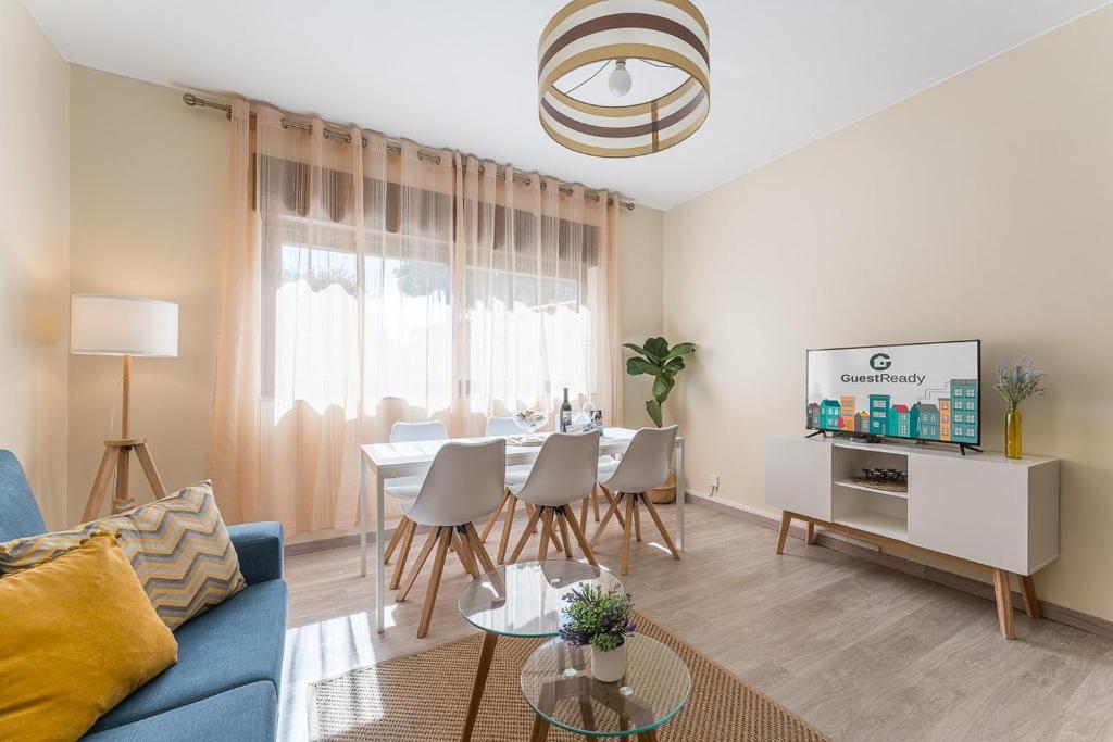 sala de estar con sofá azul y mesa en GuestReady - Sunny Family Apt with Private Terrace, en Oporto