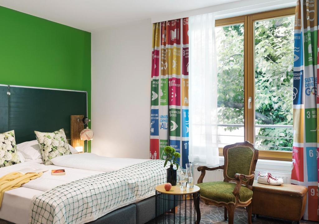 een slaapkamer met een bed, een stoel en een raam bij Boutiquehotel Stadthalle in Wenen