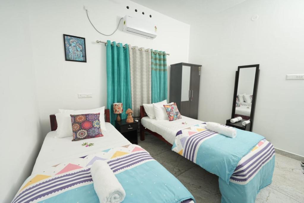 2 camas en una habitación con cortinas verdes en VILLA MANTRAA, en Varkala