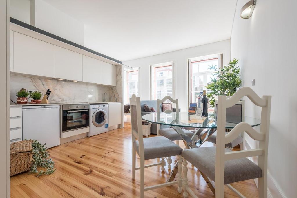 a kitchen and dining room with a glass table at GuestReady - Coral Apartment in Porto