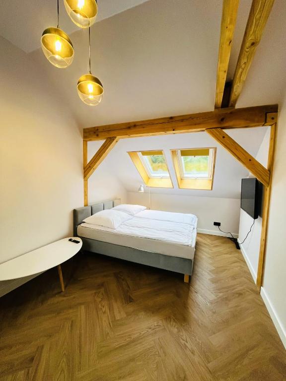 a bedroom with a bed and two windows at RADO Aparts in Lądek-Zdrój
