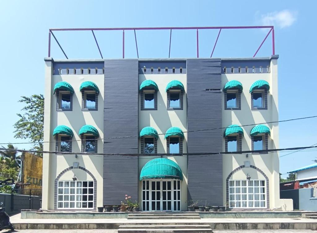 a building with turquoise awnings at Diviyum Manor in Port Blair