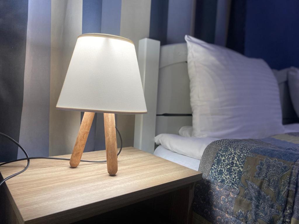 una lámpara en una mesa junto a una cama en Hillside Guesthouse, en Borjomi