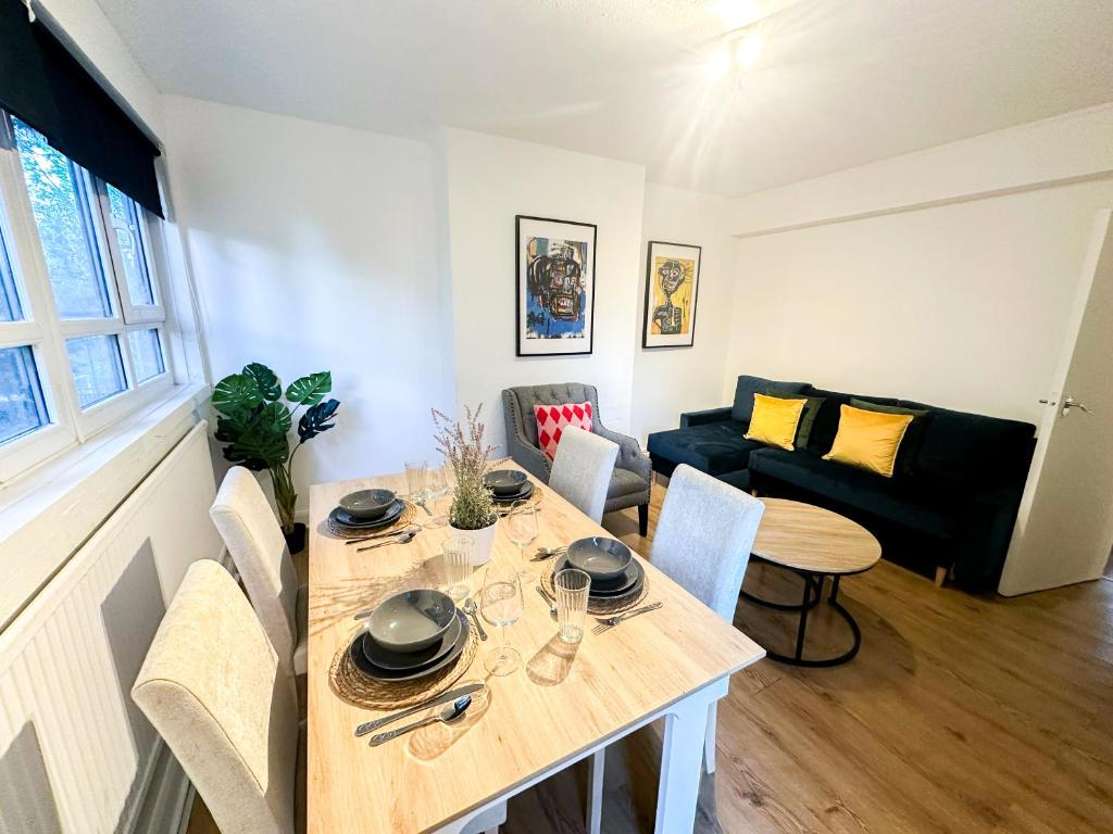 salon ze stołem i kanapą w obiekcie Vibrant 3BR flat near Finsbury Park w Londynie