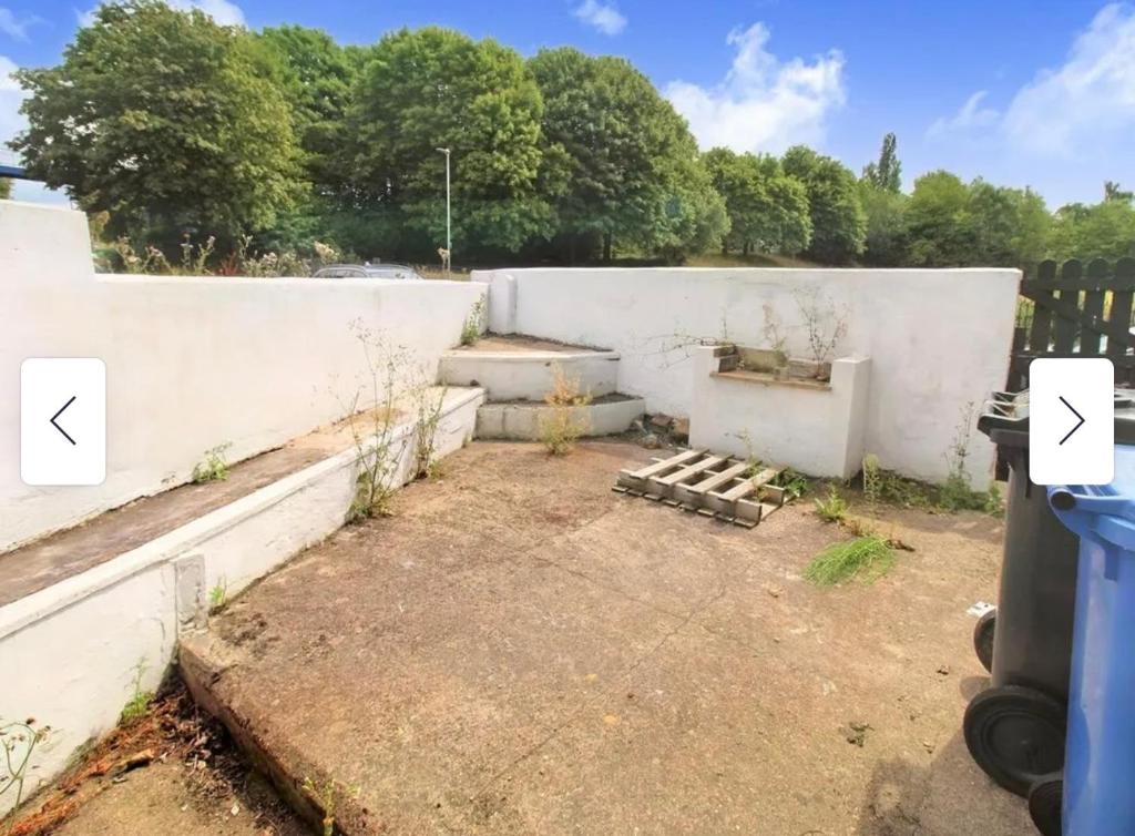 a backyard with a white wall and a fence at 29 ASHBURTON STREET in Stoke on Trent
