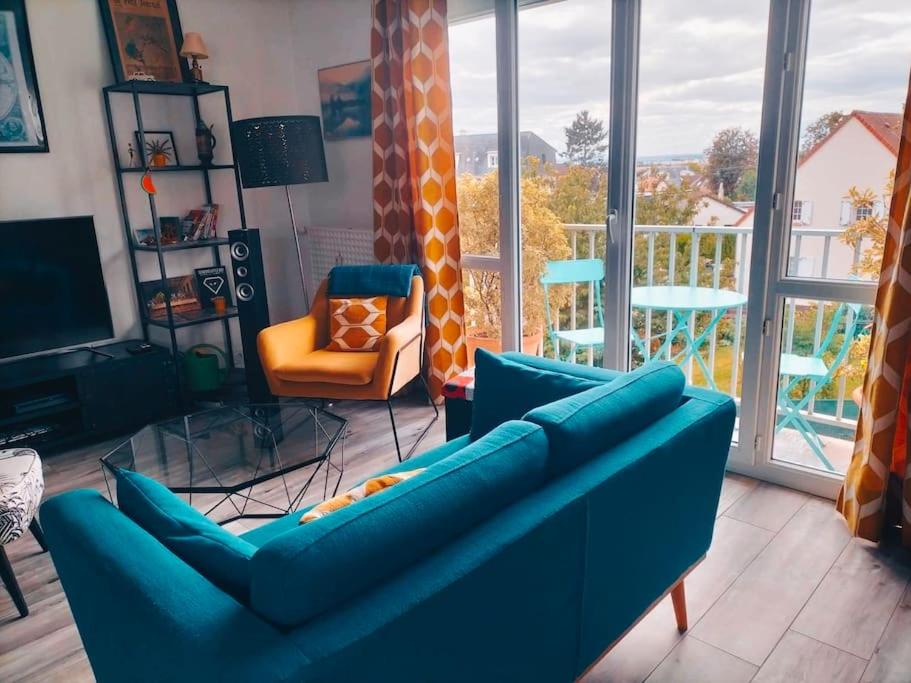 - un salon avec un canapé bleu et une chaise orange dans l'établissement Cozy apartment free parking CAEN, à Caen