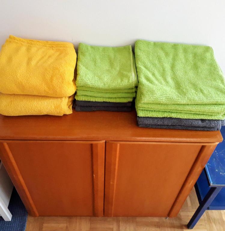 two green and yellow towels sitting on top of a wooden table at Green City Center Shared Apartment in Bad Ischl