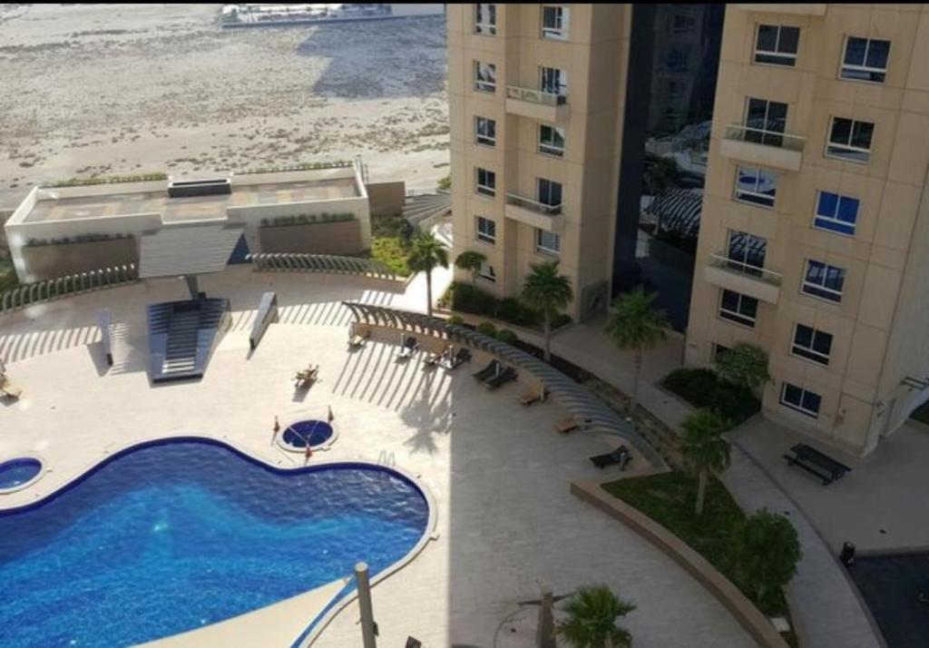 an aerial view of a hotel with a swimming pool and the beach at Cozy Lovely Apartment in Manama