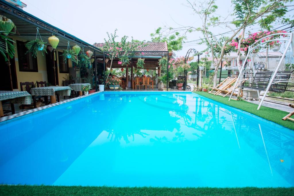 duży basen z niebieską wodą przed domem w obiekcie Phong Nha Ecolodge w mieście Phong Nha