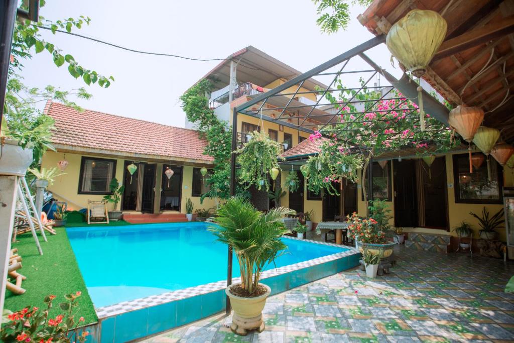 a villa with a swimming pool in front of a house at Phong Nha Ecolodge in Phong Nha