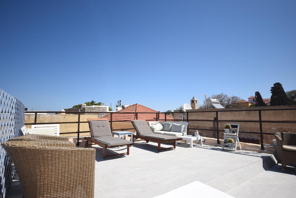 a patio with chairs and tables on a roof at Masì House in Rhodes Town