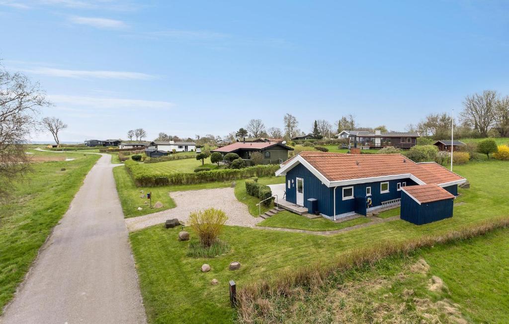 een blauw huis op een veld met een onverharde weg bij 3 Bedroom Amazing Home In Tranekr in Tranekær