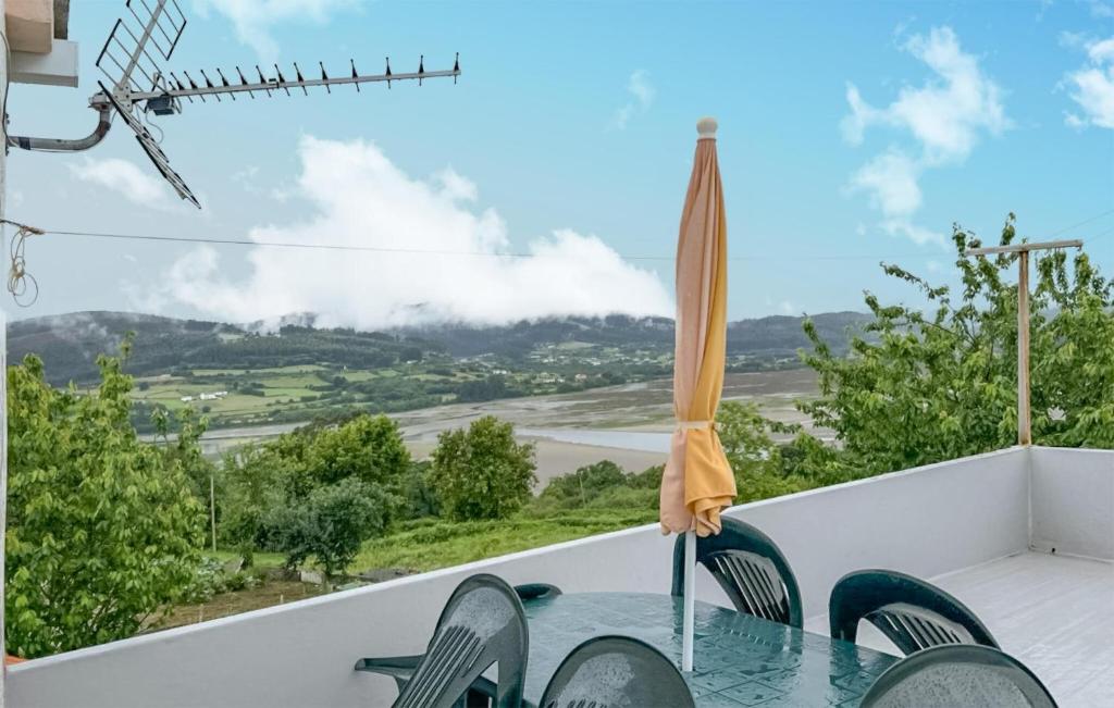ポルト・デ・エスパサンデにあるStunning Apartment In O Porto De Espasante With Wifiの景色を望むバルコニー(傘付きのテーブル付)