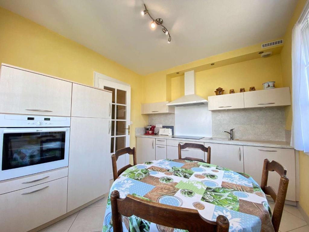 a kitchen with a table and a kitchen with yellow walls at Maison Pornichet, 3 pièces, 6 personnes - FR-1-245-155 in Pornichet