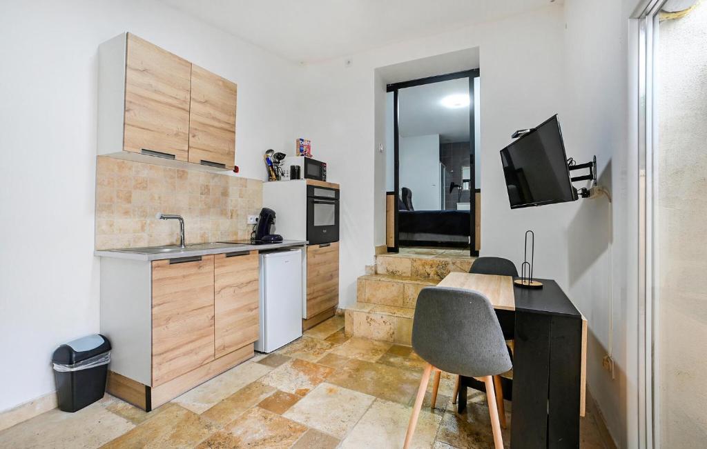 Il comprend une cuisine avec un évier et un bureau avec une télévision. dans l'établissement Nice Apartment In Jonquières-Saint-Vince, à Jonquières-et-Saint-Vincent